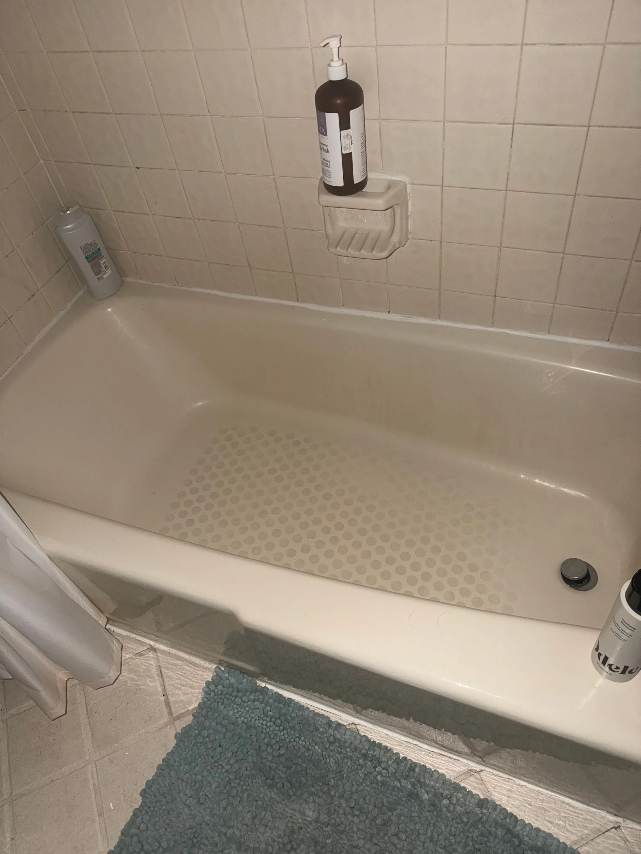 Bathtub with a white tile surround.