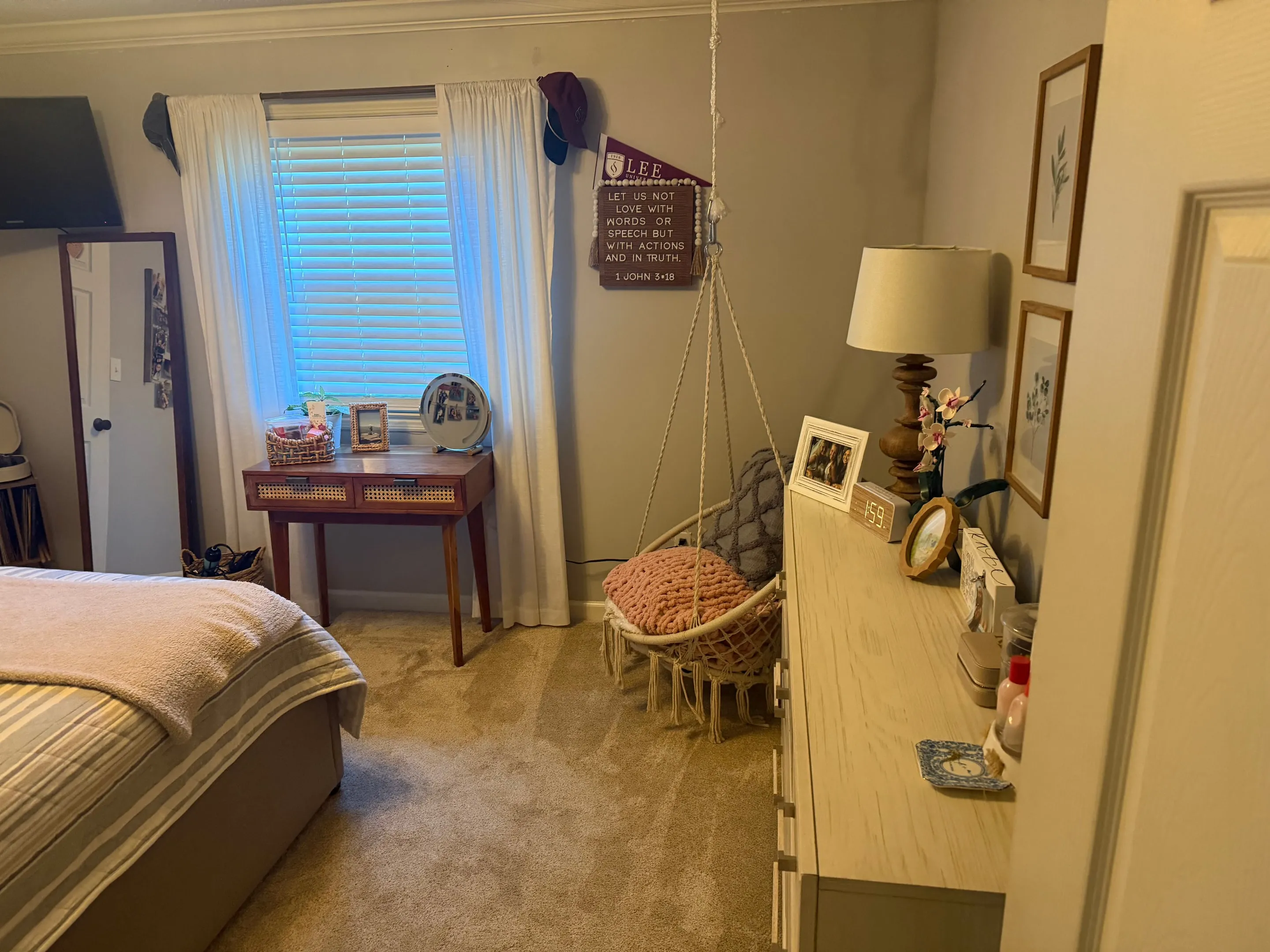 Carpeted bedroom with a window, a small desk, and a hanging chair.
