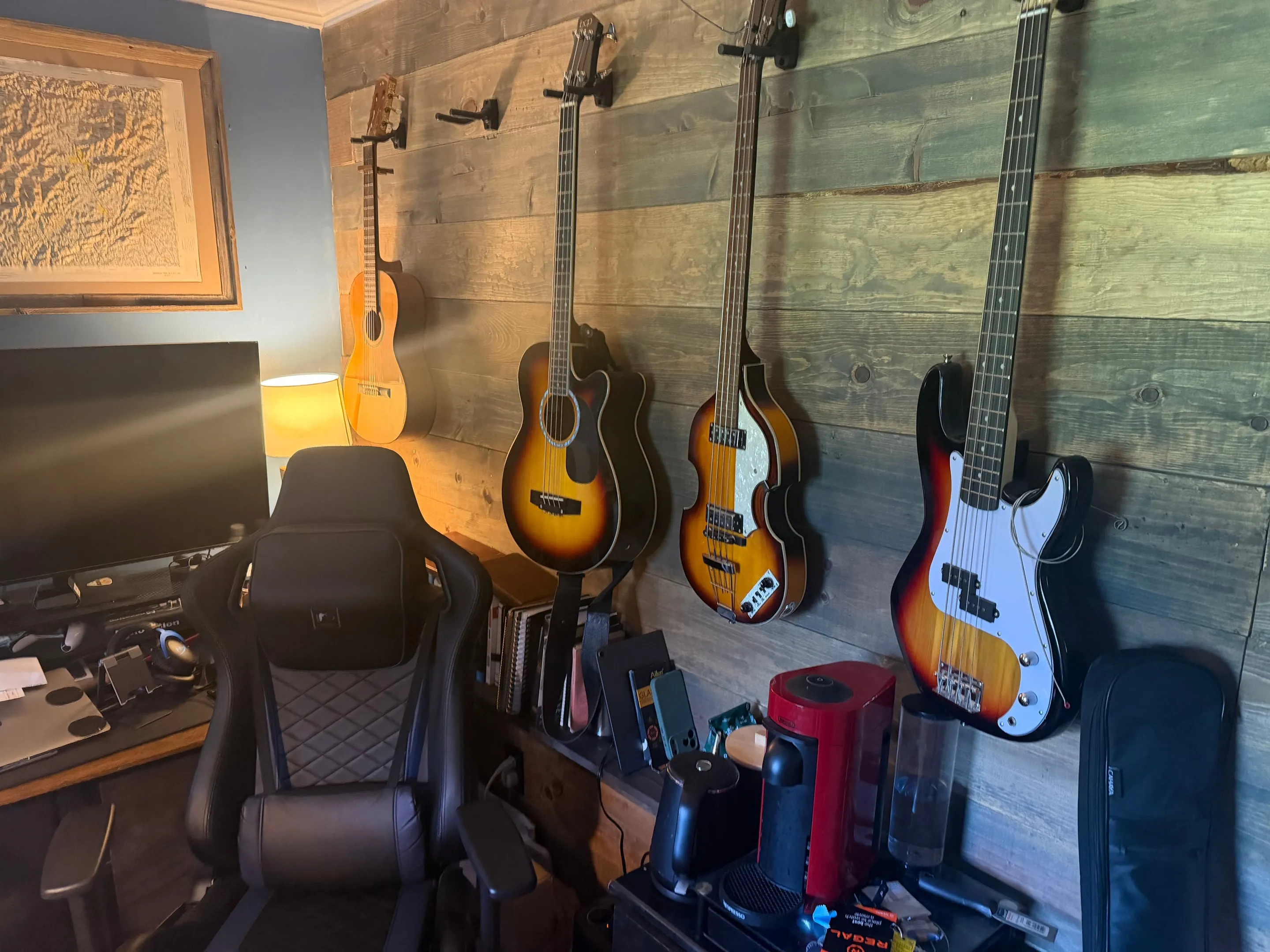 Reclaimed-style wood plank wall with guitars hanging on it.