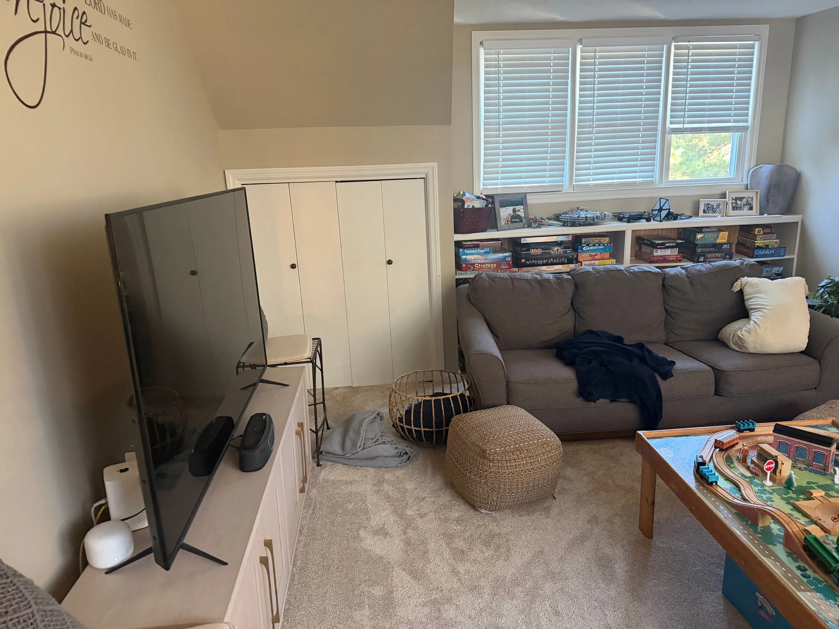 Built-in shelves under a row of windows, with a closet beside them.