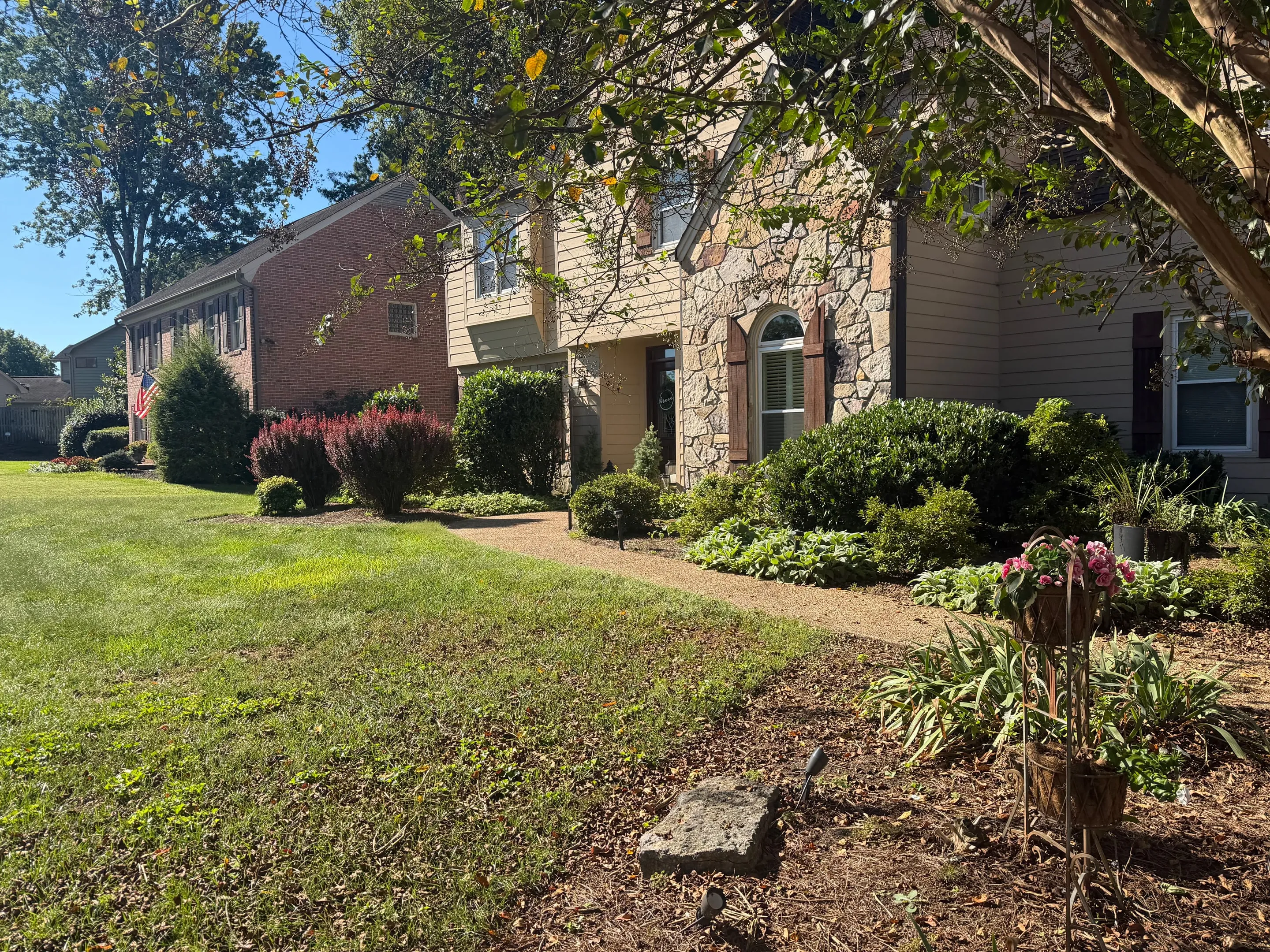 Front lawn and landscaped beds leading to the front door.