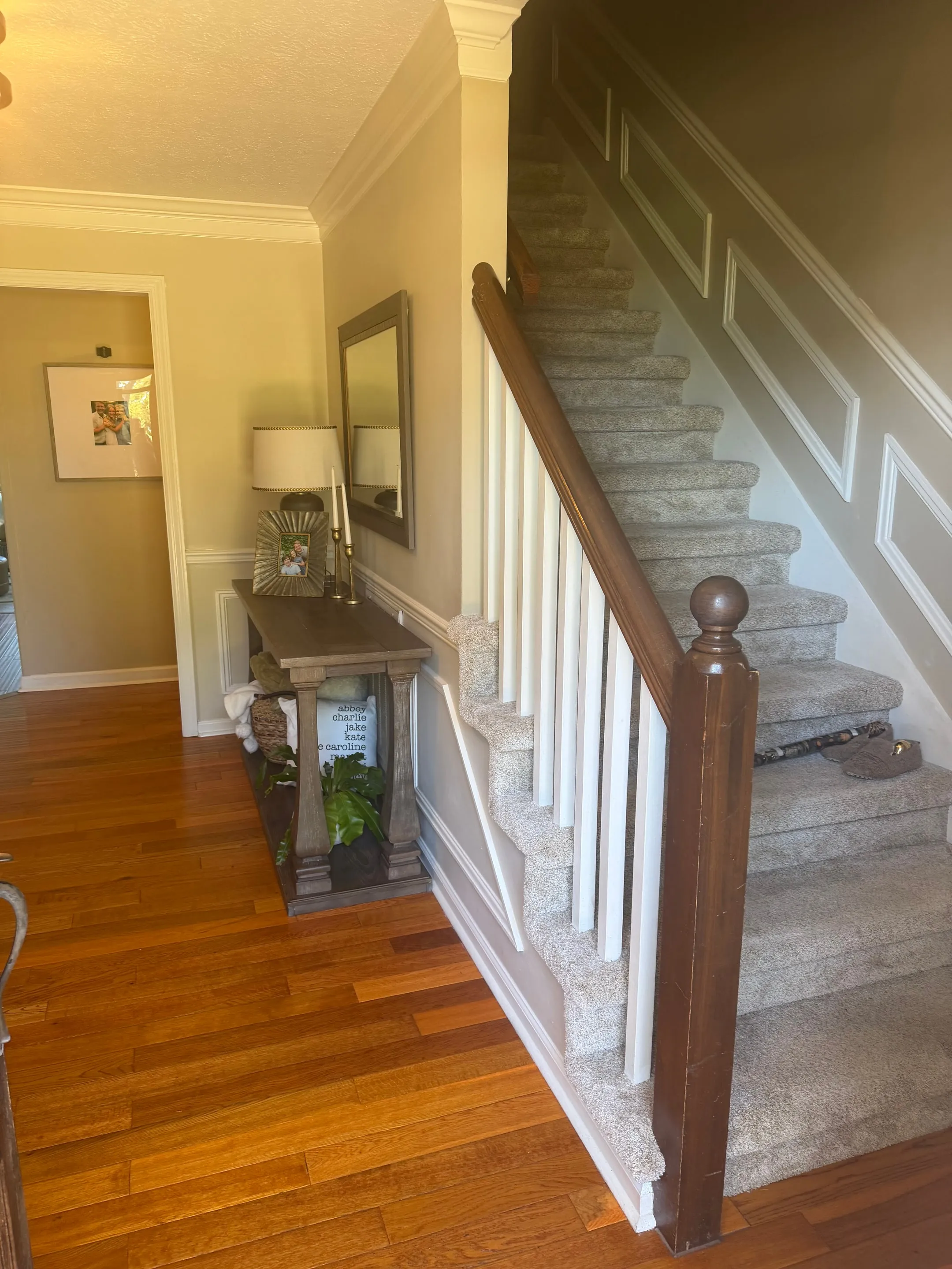 Carpeted staircase with white balusters and a wood newel post.