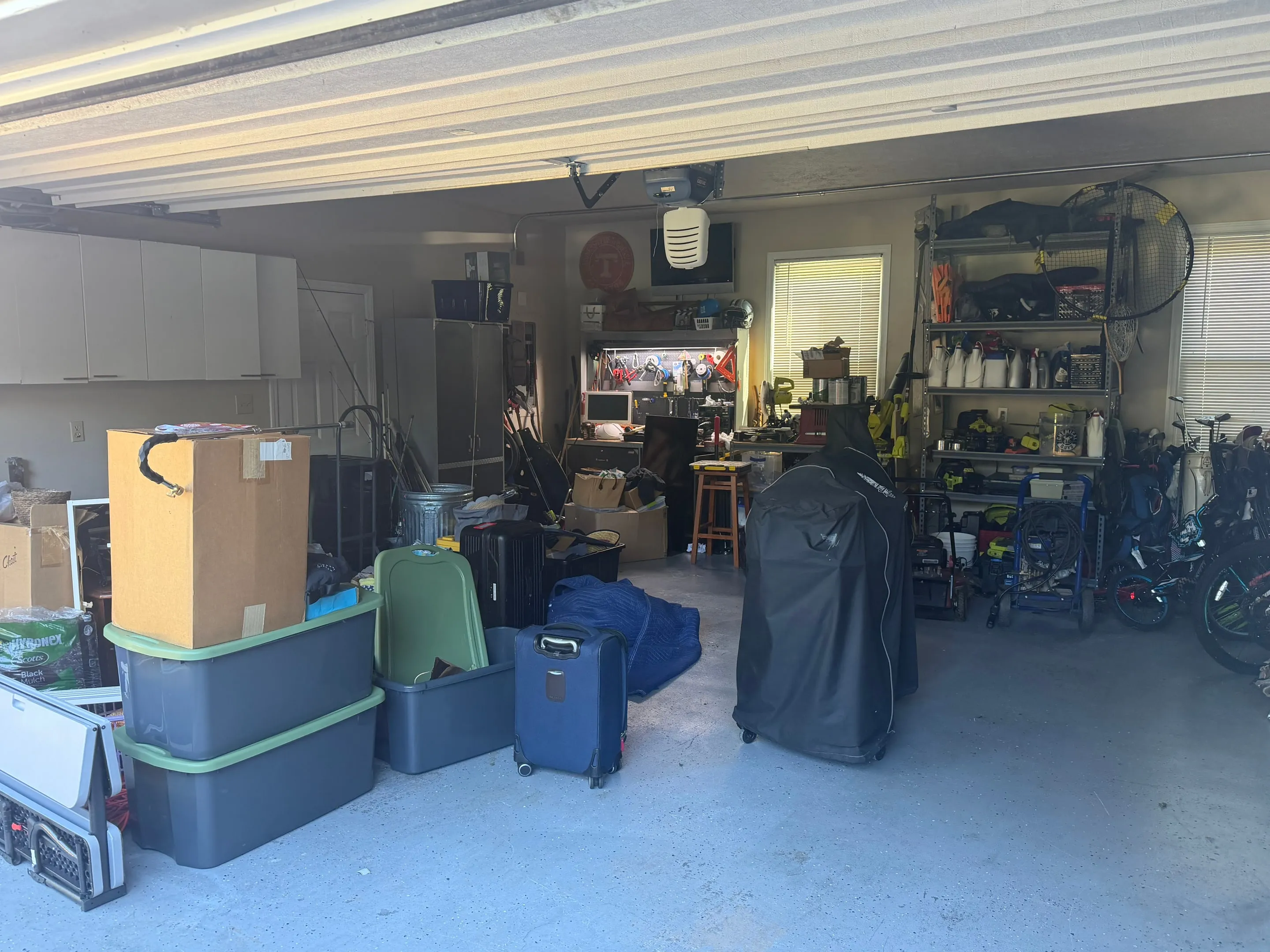 Open two-car garage with wall cabinets and shelving.