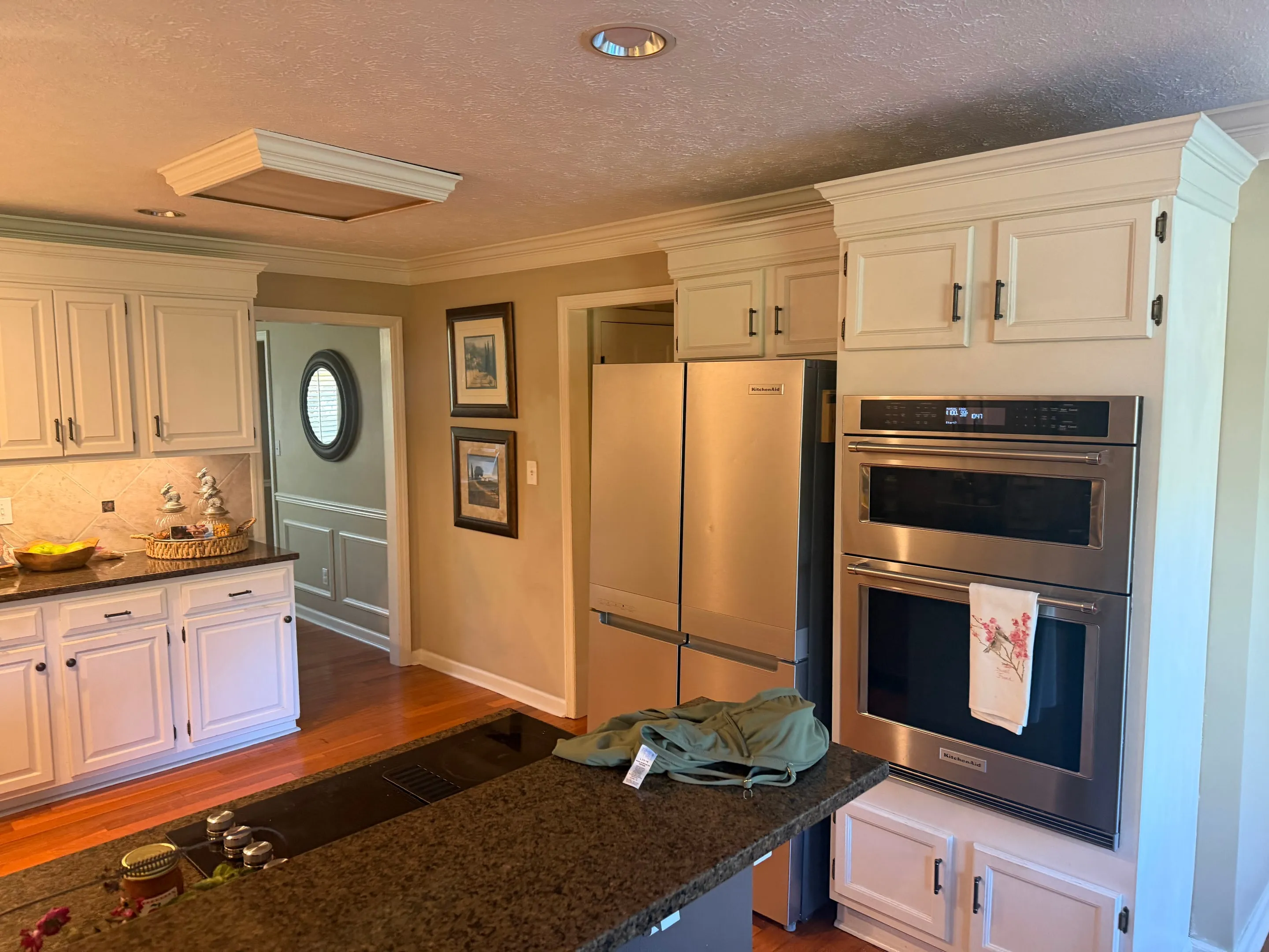 Stainless wall oven with a microwave above it, next to a stainless refrigerator.