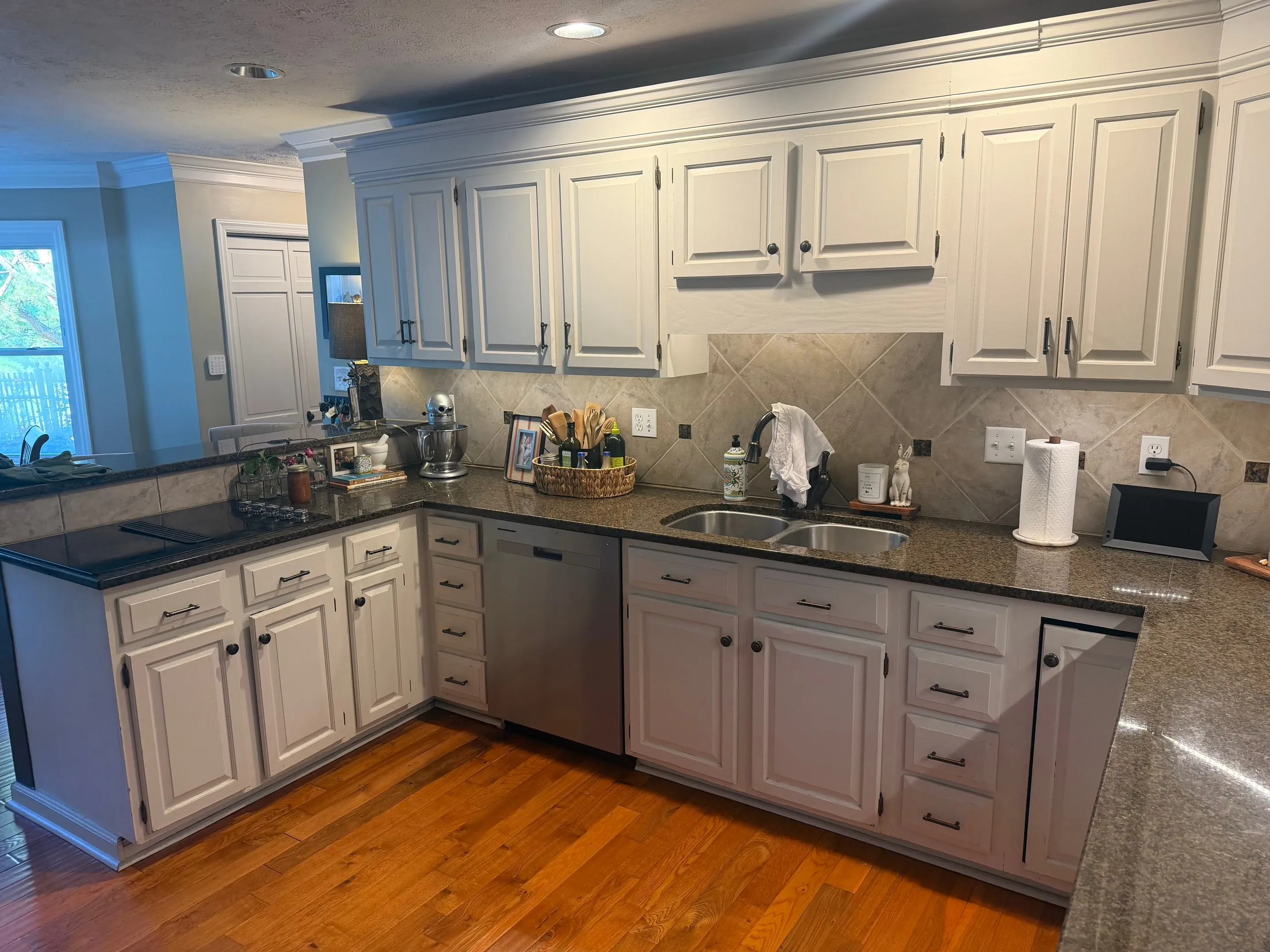 Kitchen peninsula with a cooktop, seen with the sink wall and dishwasher behind it.