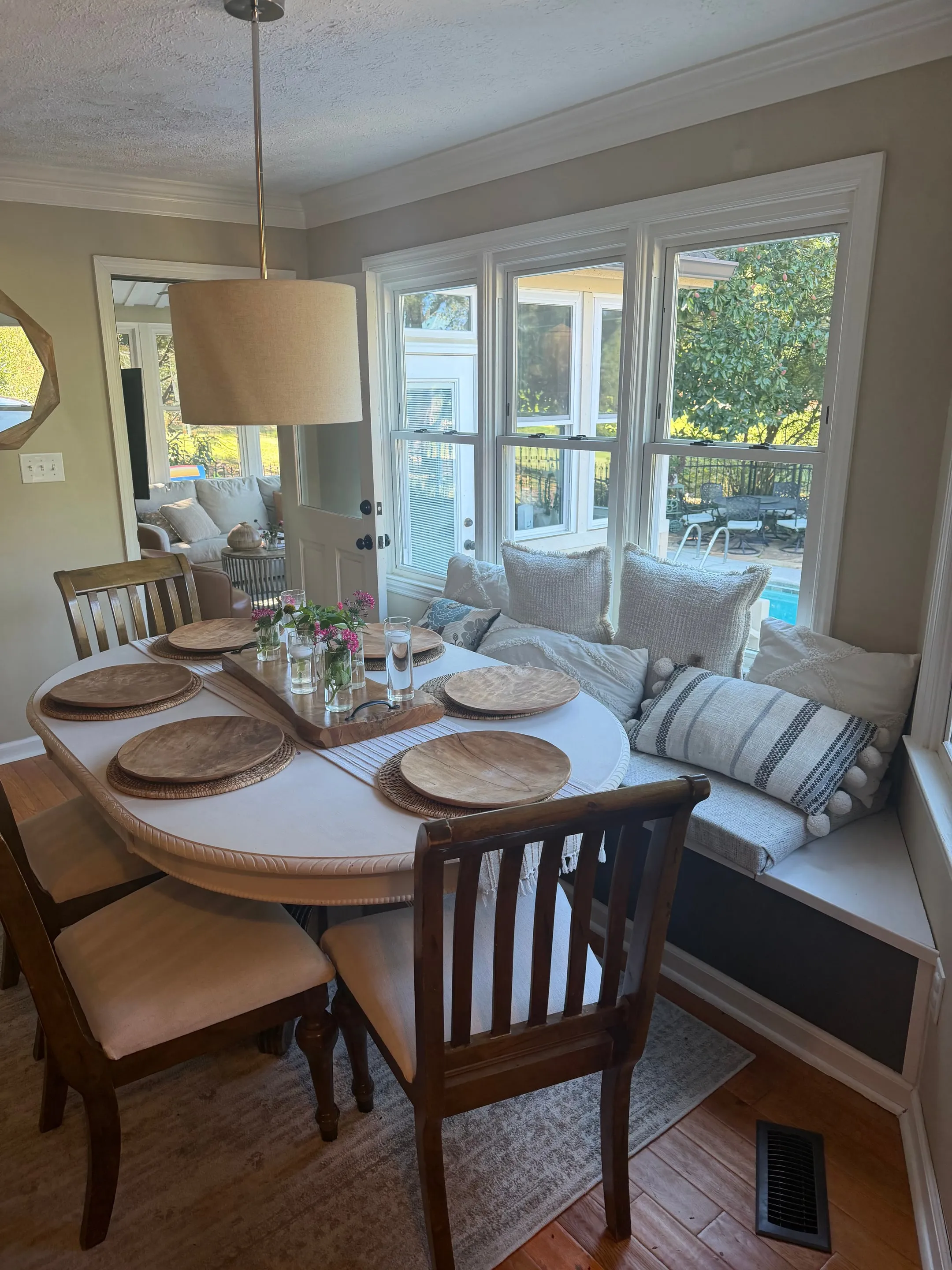 Table and window bench with a view through the windows to the sunroom and pool.