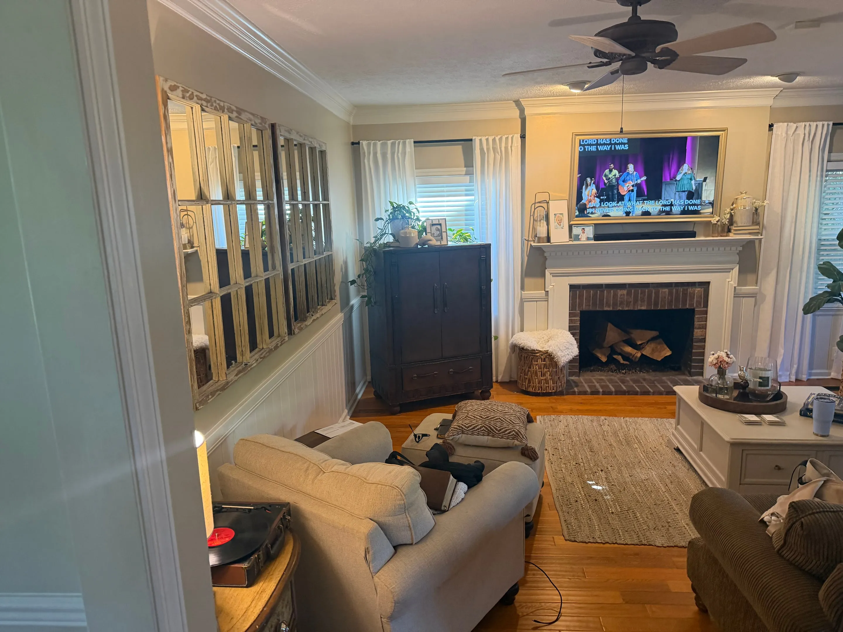 Brick fireplace with a white mantel and a television above it, seen from the doorway.