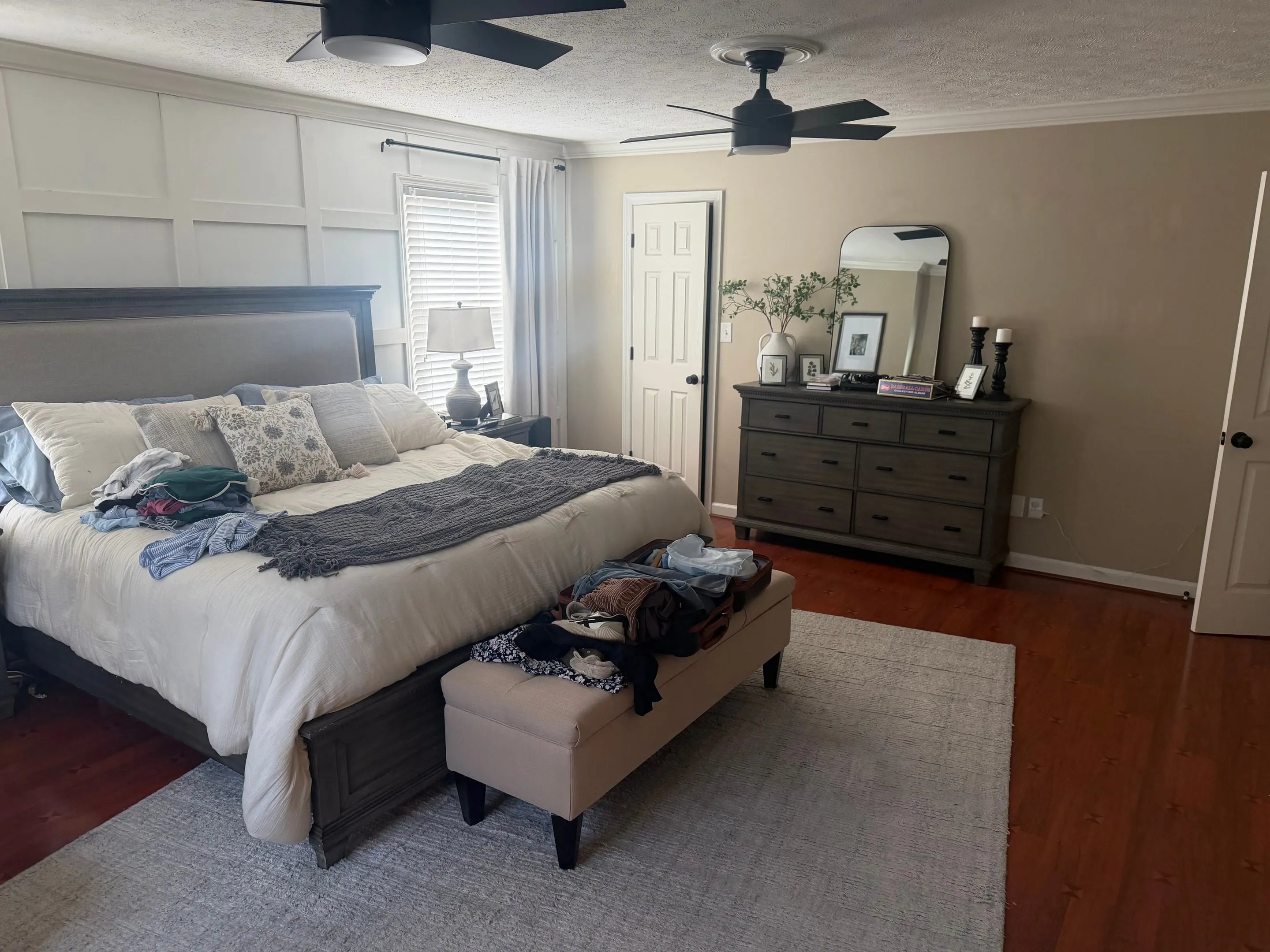 Primary bedroom showing the bed, a dresser with a mirror, and a closet door.